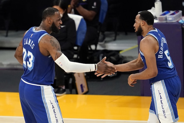 Los Angeles Lakers forward LeBron James (23) shakes hands with guard Talen Horton-Tucker (5) during the second half of the team's NBA basketball game against the Denver Nuggets on Thursday, Feb. 4, 2021, in Los Angeles. (AP Photo/Marcio Jose Sanchez)