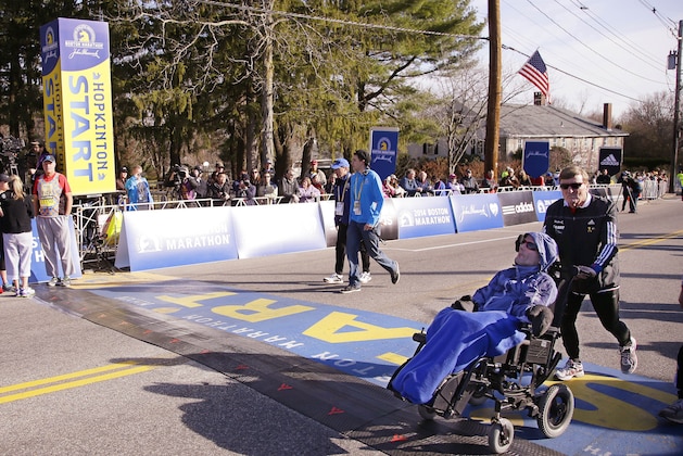 Father and son Boston Marathon race team Dick Hoyt, right, and his son Rick Hoyt walk across the start line as they warm up before they run the 118th Boston Marathon Monday, April 21, 2014 in Hopkinton, Mass. (AP Photo/Stephan Savoia)