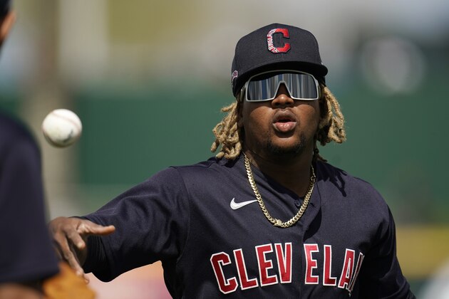 Cleveland Indians' Jose Ramirez flips the ball to a teammate prior to the team's spring training baseball game against the Los Angeles Dodgers on Friday, March 12, 2021, in Goodyear, Ariz. (AP Photo/Ross D. Franklin)
