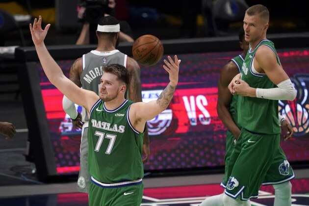 Dallas Mavericks guard Luka Doncic (77) celebrates his basket as Los Angeles Clippers' Marcus Morris Sr., rear, walks past and Mavericks' Kristaps Porzingis, right, looks over during the second half of an NBA basketball game in Dallas, Wednesday, March 17, 2021. Doncic scored 42 points in the 105-89 Mavericks win. (AP Photo/Tony Gutierrez)