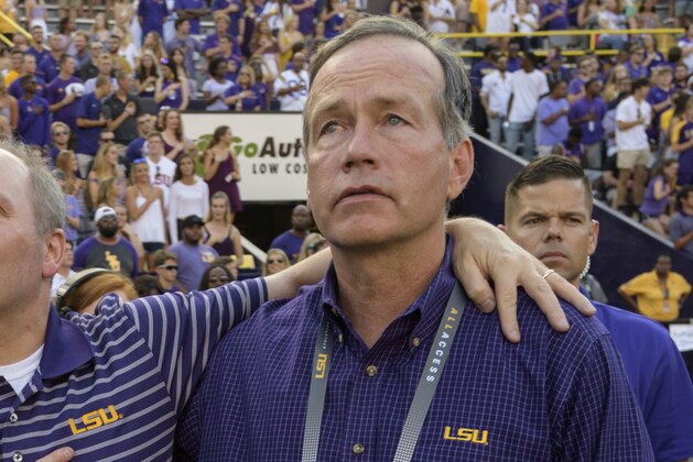 House Majority Whip Steve Scalise, R-La., gets help standing for the national anthem from his wife Jennifer Scalise, left, and F. King Alexander, LSU President and Chancellor with before an NCAA college football game against Troy in Baton Rouge, La., Saturday, Sept. 30, 2017. Scalise is an LSU alumnus and recently returned to public life after being shot in Washington D.C. (AP Photo/Matthew Hinton)