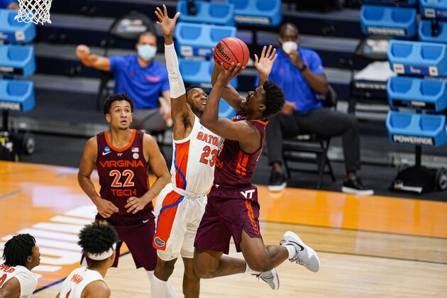 Virginia Tech guard Nahiem Alleyne (4) shoots over Florida guard Scottie Lewis (23) in the first half of a first round game in the NCAA men's college basketball tournament at Hinkle Fieldhouse in Indianapolis, Friday, March 19, 2021. (AP Photo/Michael Conroy)