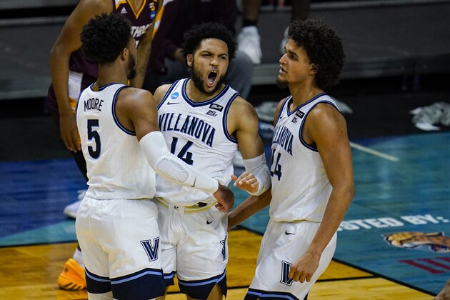 Villanova guard Caleb Daniels (14) celebrates a defensive stop with Justin Moore (5) and Jeremiah Robinson-Earl (24) in the second half of a first round game against Winthrop in the NCAA men's college basketball tournament at Farmers Coliseum in Indianapolis, Friday, March 19, 2021. (AP Photo/Michael Conroy)