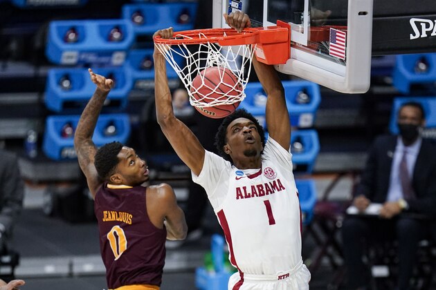 Alabama forward Herbert Jones (1) gets a basket on a dunk over Iona guard Berrick JeanLouis (0) in the first half of a first-round game in the NCAA men's college basketball tournament at Hinkle Fieldhouse in Indianapolis, Saturday, March 20, 2021. (AP Photo/Michael Conroy)