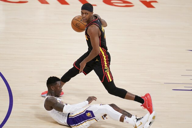 Los Angeles Lakers guard Dennis Schroder, bottom, falls down under Atlanta Hawks guard Rajon Rondo during the second half of an NBA basketball game Saturday, March 20, 2021, in Los Angeles. (AP Photo/Marcio Jose Sanchez)