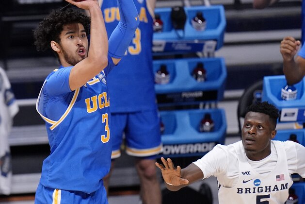 UCLA guard Johnny Juzang (3) takes a three point shot as BYU forward Gideon George (5) defends during the second half of a first-round game in the NCAA college basketball tournament at Hinkle Fieldhouse in Indianapolis, Saturday, March 20, 2021. (AP Photo/AJ Mast)
