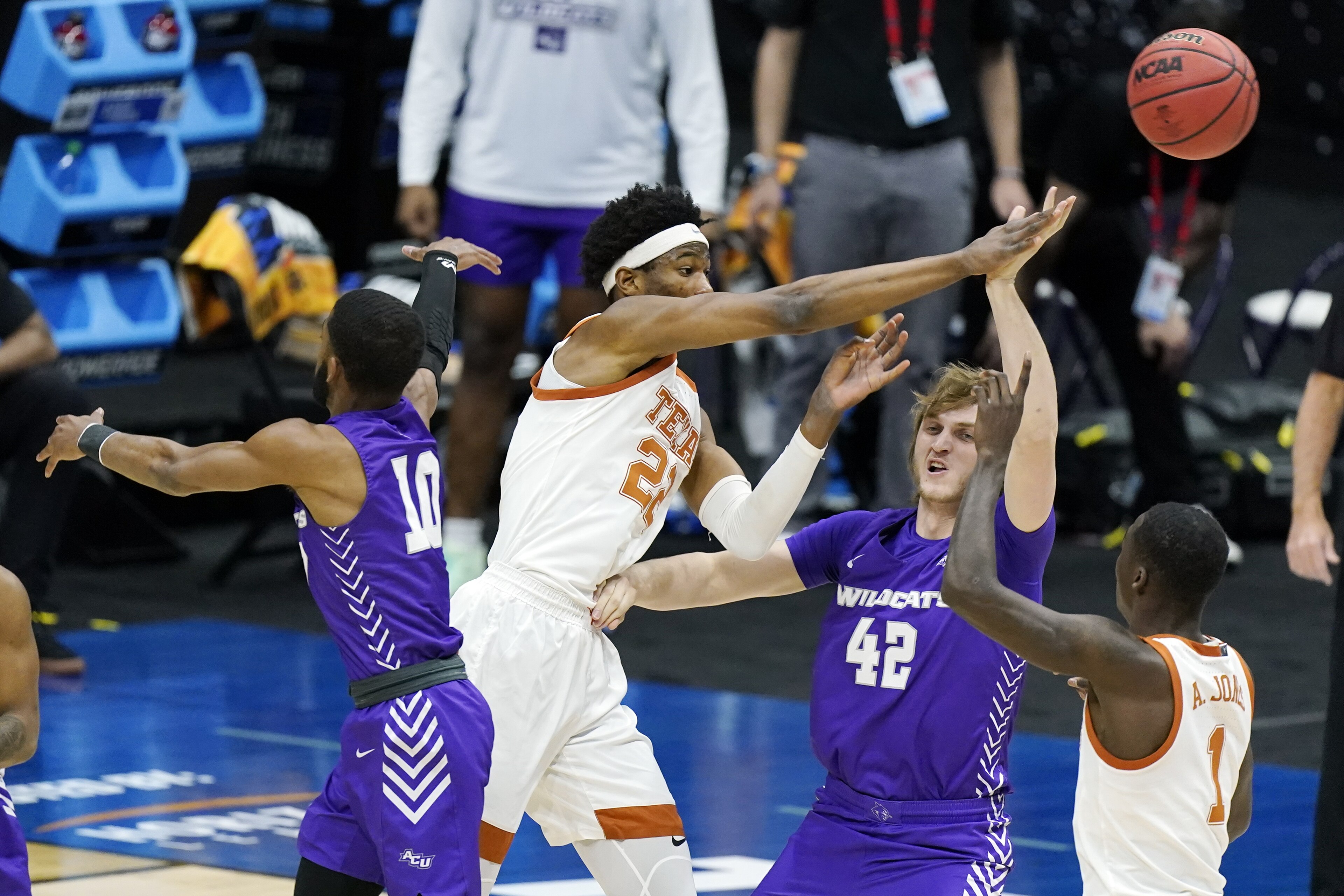 Texas' Kai Jones (22) passes the ball over Abilene Christian's Clay Gayman (42) during the first half of a college basketball game in the first round of the NCAA tournament at Lucas Oil Stadium in Indianapolis Saturday, March 20, 2021. (AP Photo/Mark Humphrey)