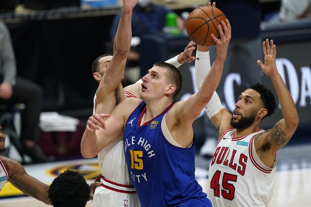 Denver Nuggets center Nikola Jokic, center, drives to the basket between Chicago Bulls guards Zach LaVine, left, and Denzel Valentine during the second half of an NBA basketball game Friday, March 19, 2021, in Denver. The Nuggets won 131-127 in overtime. (AP Photo/David Zalubowski)