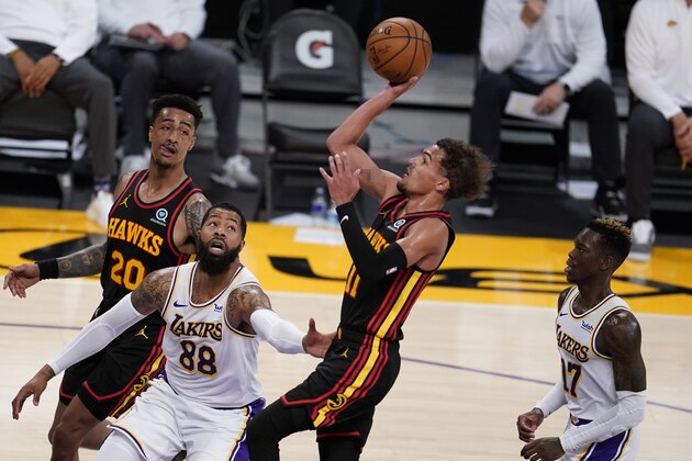 CORRECTS TO SECOND HALF, NOT FIRST HALF - Atlanta Hawks guard Trae Young, center, shoots over Los Angeles Lakers forward Markieff Morris, left, and Dennis Schroder, left, during the second half of an NBA basketball game Saturday, March 20, 2021, in Los Angeles. (AP Photo/Marcio Jose Sanchez)