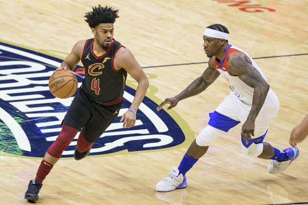 Newly signed Cleveland Cavaliers guard Quinn Cook (4) dribbles around New Orleans Pelicans guard Eric Bledsoe (5) in the first half of an NBA basketball game in New Orleans, Friday, March 12, 2021. (AP Photo/Matthew Hinton)