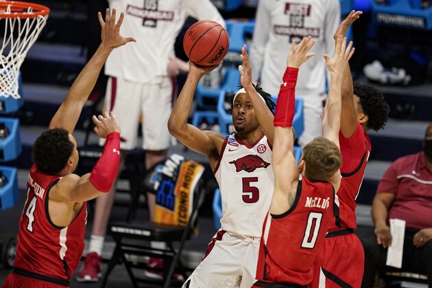 Arkansas guard Moses Moody (5) shoots over Texas Tech forward Marcus Santos-Silva (14) and guard Mac McClung (0) in the second half of a second-round game in the NCAA men's college basketball tournament at Hinkle Fieldhouse in Indianapolis, Sunday, March 21, 2021. (AP Photo/Michael Conroy)