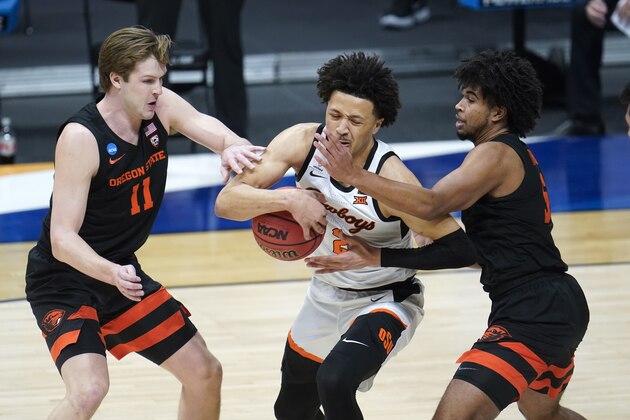 Oklahoma State guard Cade Cunningham (2) drives between Oregon State guard Zach Reichle (11) and Ethan Thompson (5) during the first half of a men's college basketball game in the second round of the NCAA tournament at Hinkle Fieldhouse in Indianapolis, Sunday, March 21, 2021. (AP Photo/Paul Sancya)