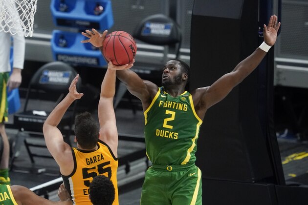 Iowa's Luka Garza (55) has his shot blocked by Oregon's Eugene Omoruyi (2) during the first half of a second-round game in the NCAA men's college basketball tournament at Bankers Life Fieldhouse, Monday, March 22, 2021, in Indianapolis. (AP Photo/Darron Cummings)