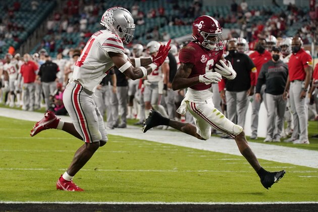 Alabama wide receiver DeVonta Smith scores a touchdown past Ohio State safety Josh Proctor during the first half of an NCAA College Football Playoff national championship game, Monday, Jan. 11, 2021, in Miami Gardens, Fla. (AP Photo/Chris O'Meara)