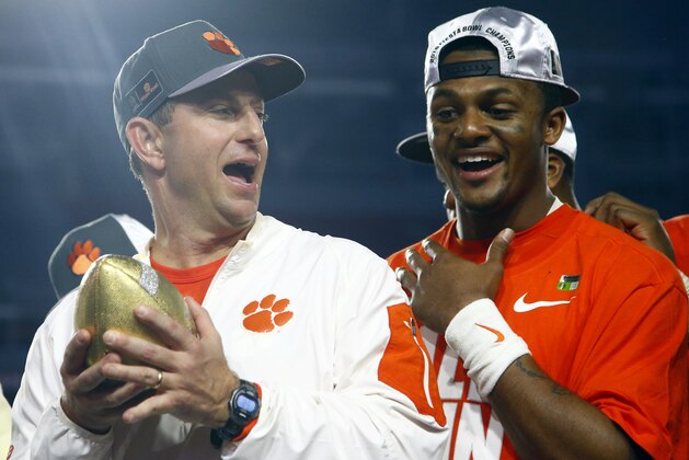 Clemson head coach Dabo Swinney holds the champions trophy as Clemson quarterback Deshaun Watson looks on after the Fiesta Bowl NCAA college football game against Ohio State, Saturday, Dec. 31, 2016, in Glendale, Ariz. Clemson won 31-0 to advance to the BCS championship game on Jan. 9th against Alabama. (AP Photo/Ross D. Franklin) Clemson head coach Dabo Swinney holds the champions trophy as Clemson quarterback Deshaun Watson looks on after the Fiesta Bowl NCAA college football game against Ohio State, Saturday, Dec. 31, 2016, in Glendale, Ariz. Clemson won 31-0 to advance to the BCS championship game on Jan. 9th against Alabama. (AP Photo/Ross D. Franklin)