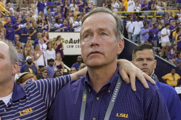 House Majority Whip Steve Scalise, R-La., gets help standing for the national anthem from his wife Jennifer Scalise, left, and F. King Alexander, LSU President and Chancellor with before an NCAA college football game against Troy in Baton Rouge, La., Saturday, Sept. 30, 2017. Scalise is an LSU alumnus and recently returned to public life after being shot in Washington D.C. (AP Photo/Matthew Hinton)