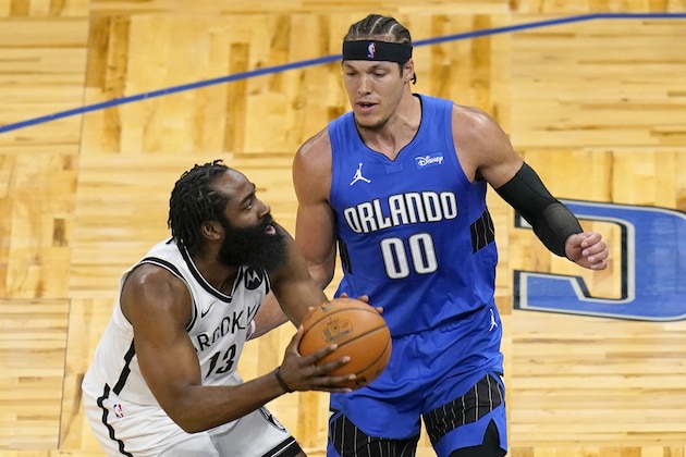 Brooklyn Nets guard James Harden, left, takes a shot against Orlando Magic forward Aaron Gordon (00) during the first half of an NBA basketball game, Friday, March 19, 2021, in Orlando, Fla. (AP Photo/John Raoux)