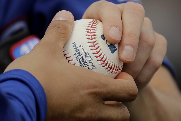 Texas Rangers pitchers Cole Hamels, right, and Yu Darvish talk about gripping the ball during spring training baseball practice Wednesday, Feb. 22, 2017, in Surprise, Ariz. (AP Photo/Charlie Riedel)