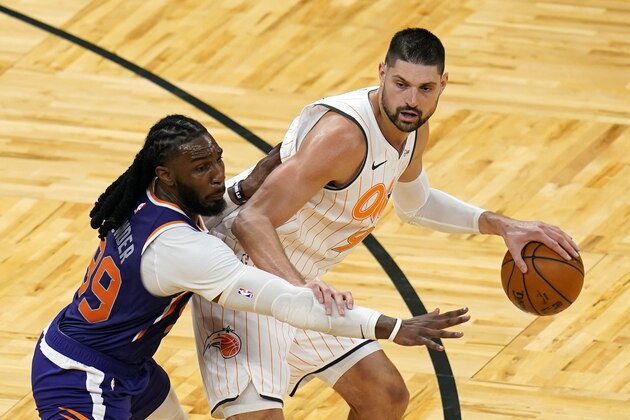 Orlando Magic center Nikola Vucevic, right, looks to get around Phoenix Suns forward Jae Crowder during the second half of an NBA basketball game, Wednesday, March 24, 2021, in Orlando, Fla. (AP Photo/John Raoux)