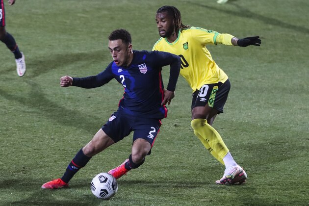 USA's Sergino Dest, left, duels for the ball with Jamaica's Kasey Palmer during the international friendly soccer match between USA and Jamaica at SC Wiener Neustadt stadium in Wiener Neustadt, Austria, Thursday, March 25, 2021. (AP Photo/Ronald Zak)