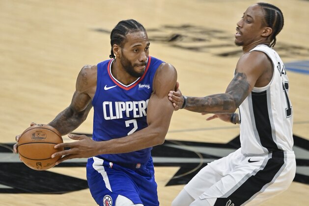Los Angeles Clippers' Kawhi Leonard, left, drives against San Antonio Spurs' DeMar DeRozan during the second half of an NBA basketball game on Wednesday, March 24, 2021, in San Antonio. Los Angeles won 134-101. (AP Photo/Darren Abate)