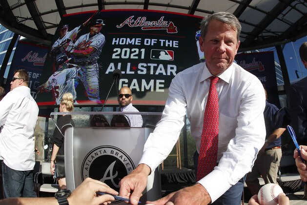 Georgia Gov. Brian Kemp signs a baseball after a ceremony to announce that Atlanta will host baseball's 2021 All-Star Game, Wednesday, May 29, 2019, in Atlanta. (AP Photo/John Bazemore)