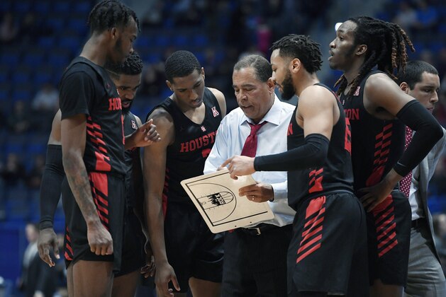 FILE - In this Feb. 14, 2019, file photo, Houston head coach Kelvin Sampson talks to his team during the first half of an NCAA college basketball game against Connecticut, in Hartford, Conn. The entire team piles into Sampson's house before each home game to prepare for the next opponent, eat his wife Karen's delicious homemade chocolate chip cookies and bond like a family. The routine is something Sampson and his players agree has created an environment of closeness and trust that is an integral ingredient in the ninth-ranked Cougars' success this season.(AP Photo/Jessica Hill, File)