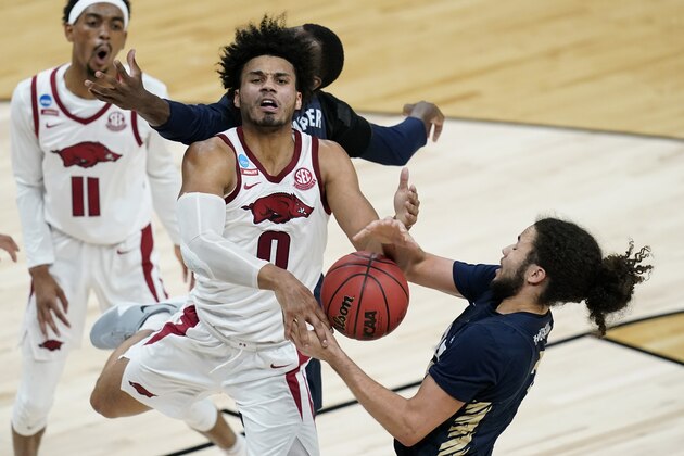 Oral Roberts guard Kareem Thompson, right, tries to steal the ball from Arkansas forward Justin Smith (0) during the second half of a Sweet 16 game in the NCAA men's college basketball tournament at Bankers Life Fieldhouse, Saturday, March 27, 2021, in Indianapolis. (AP Photo/Darron Cummings)
