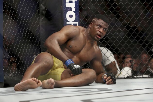 Francis Ngannou has trouble getting up at the end of round three against Stipe Miocic during a heavyweight championship mixed martial arts bout at UFC 220, early Sunday, Jan. 21, 2018, in Boston. Miocic retained his title via unanimous decision. (AP Photo/Gregory Payan)