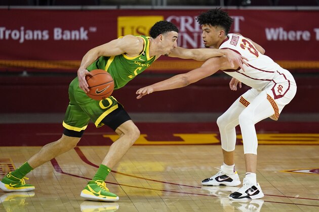Southern California forward Max Agbonkpolo (23) defends against Oregon guard Chris Duarte (5) during the second half of an NCAA college basketball game Monday, Feb. 22, 2021, in Los Angeles. (AP Photo/Ashley Landis)