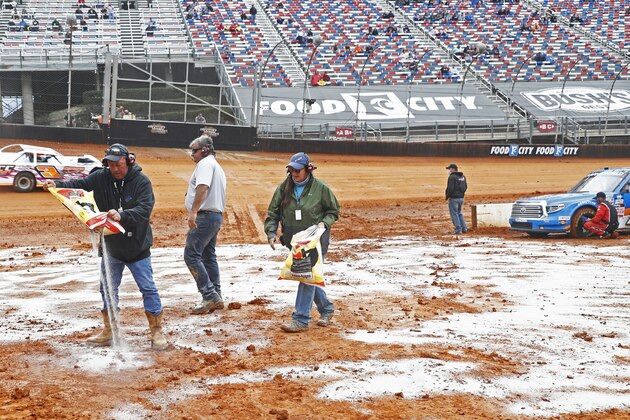 Safety workers spread drying agent before heat races for a NASCAR Truck Series race on Saturday, March 27, 2021, in Bristol, Tenn. (AP Photo/Wade Payne)