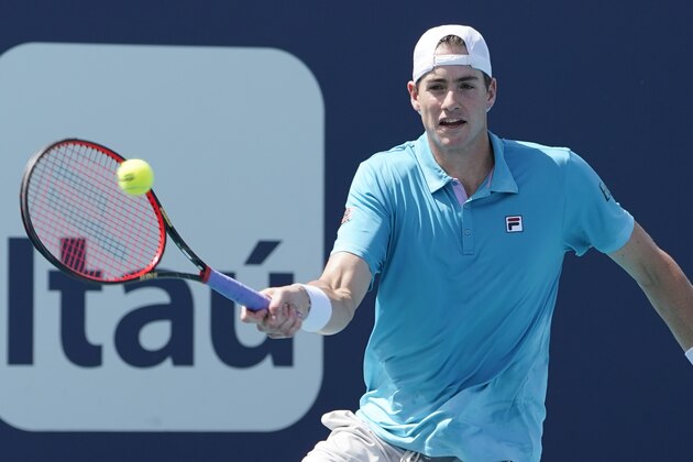 John Isner returns to Felix Auger-Aliassime of Canada during the Miami Open tennis tournament, Sunday, March 28, 2021, in Miami Gardens, Fla. (AP Photo/Marta Lavandier)
