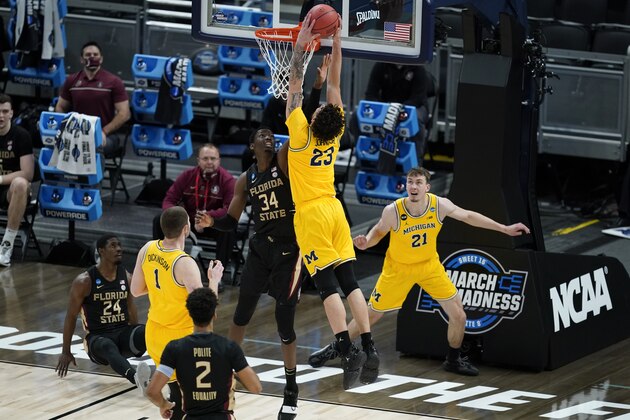 Michigan forward Brandon Johns Jr. (23) dunks over Florida State center Tanor Ngom (34) during the first half of a Sweet 16 game in the NCAA men's college basketball tournament at Bankers Life Fieldhouse, Sunday, March 28, 2021, in Indianapolis. (AP Photo/Darron Cummings)