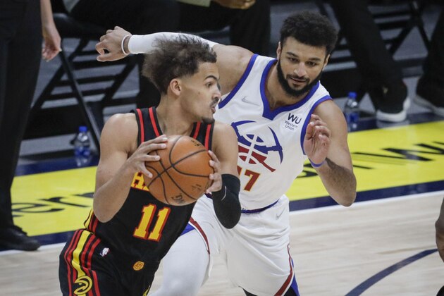 Atlanta Hawks guard Trae Young (11) drives past Denver Nuggets guard Jamal Murray (27) during the first quarter of an NBA basketball game in Denver, Sunday, March 28, 2021. (AP Photo/Joe Mahoney)