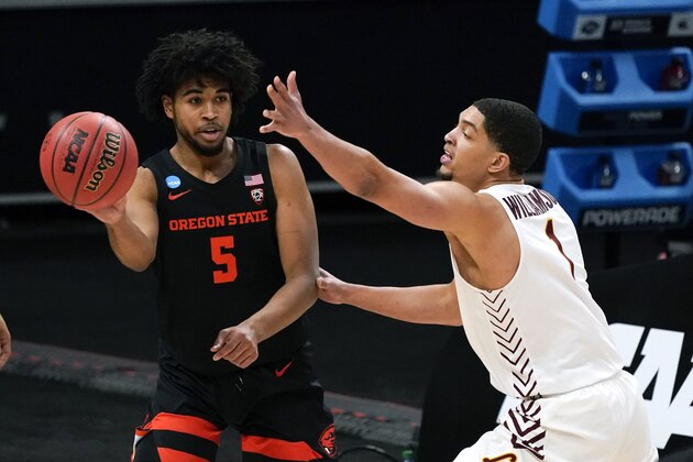 Oregon State guard Ethan Thompson (5) passes around Loyola Chicago guard Lucas Williamson (1) during the first half of a Sweet 16 game in the NCAA men's college basketball tournament at Bankers Life Fieldhouse, Saturday, March 27, 2021, in Indianapolis. (AP Photo/Jeff Roberson)