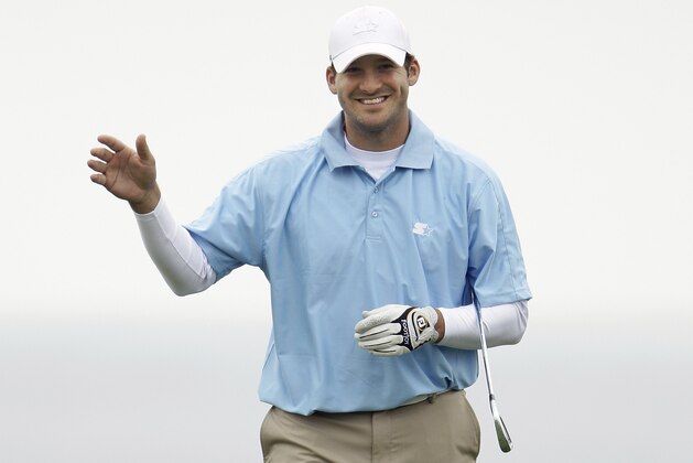 Dallas Cowboys quarterback Tony Romo waves after hitting to the eighth green at Pebble Beach Golf Links during the final round of the AT&T Pebble Beach National Pro-Am golf tournament in Pebble Beach, Calif., Sunday, Feb. 12, 2012. (AP Photo/Eric Risberg)