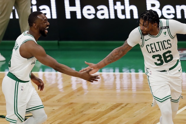 Boston Celtics' Kemba Walker reacts with Boston Celtics' Marcus Smart (36) after making a three-pointer during the second half on an NBA basketball game against the Orlando Magic, Sunday, March 21, 2021, in Boston. (AP Photo/Michael Dwyer)