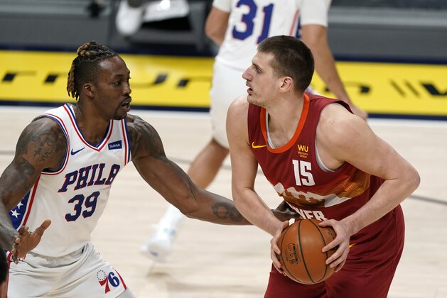 Philadelphia 76ers center Dwight Howard, left, defends as Denver Nuggets center Nikola Jokic looks to take a shot in the first half of an NBA basketball game Tuesday, March 30, 2021, in Denver. (AP Photo/David Zalubowski)
