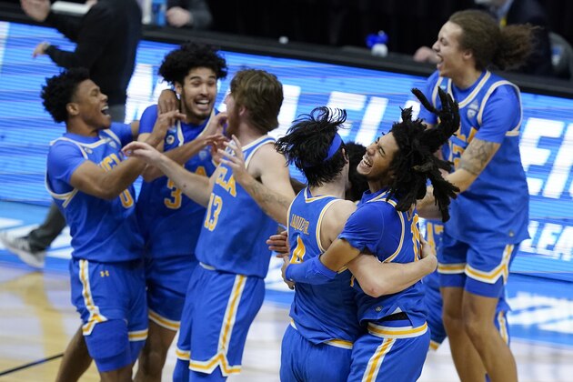 UCLA guard Tyger Campbell, right, celebrates with teammate guard Jaime Jaquez Jr. (4) after an Elite 8 game against Michigan in the NCAA men's college basketball tournament at Lucas Oil Stadium, Wednesday, March 31, 2021, in Indianapolis. UCLA won 51-49. (AP Photo/Darron Cummings)