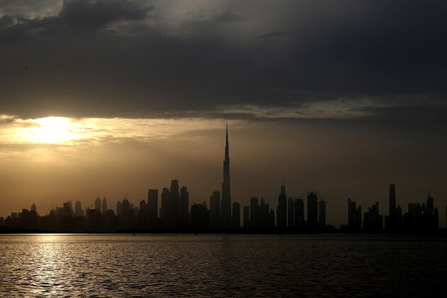 Sun sets behind the city skyline and the world tallest tower, Burj Khalifa in Dubai, United Arab Emirates, Friday, Feb. 19, 2021. (AP Photo/Kamran Jebreili)