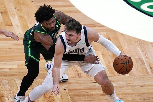 Dallas Mavericks guard Luka Doncic, right, is pressured by Boston Celtics guard Marcus Smart during the second half of an NBA basketball game Wednesday, March 31, 2021, in Boston. (AP Photo/Charles Krupa)