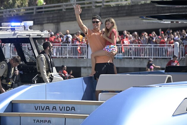 Tampa Bay Buccaneers quarterback Tom Brady holds his daughter Vivian Lake while waving to fans during a celebration of their Super Bowl 55 victory over the Kansas City Chiefs with a boat parade, Wednesday, Feb. 10, 2021, in Tampa, Fla. (AP Photo/Phelan M. Ebenhack)