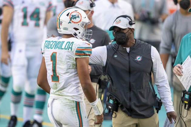 FILE - Miami Dolphins head coach Brian Flores talks to quarterback Tua Tagovailoa (1) on the sidelines as the Dolphins play against the Los Angeles Chargers during an NFL football game in Miami Gardens, Fla., in this Sunday, Nov. 15, 2020, file photo. The San Francisco 49ers have made a big move to grab their quarterback of the future by trading up with Miami for the No. 3 pick in next month's draft. For the Dolphins, the trade signals theyâ€™re not in the market for another potential franchise quarterback, and will stake their future on Tua Tagovailoa. (AP Photo/Doug Murray, File)