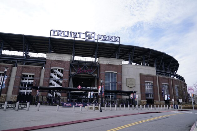 Fans arrives at Truist Park, home of the Atlanta Braves, to attend the memorial for Baseball Hall of Famer and Braves legend Hank Aaron, Tuesday, Jan. 26, 2021, in Atlanta. Just 2 1/2 weeks before his death Friday, Han 22, 2021, at age 86, Aaron joined civil rights icons to receive the COVID-19 vaccine. He wanted to spread the word to the Black community that the shots were safe in the midst of a devastating pandemic. (AP Photo/Brynn Anderson)