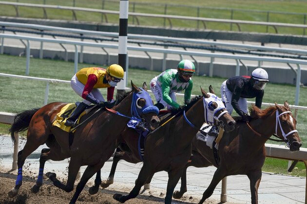 FILE - In this Friday, May 22, 2020, file photo, jockeys wearing face masks ride in the first horse race at Santa Anita in Arcadia, Calif. After a spike of horse deaths in 2019 and early 2020, Santa Anita had zero racing fatalities during its summer meet. (AP Photo/Ashley Landis, File)
