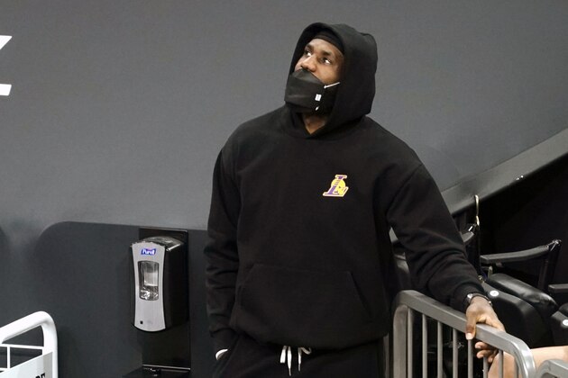 Los Angeles Lakers forward LeBron James (23) watches from the sideline during the first half of an NBA basketball game against the Phoenix Suns, Sunday, March 21, 2021, in Phoenix. (AP Photo/Rick Scuteri)