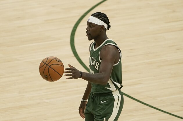 Milwaukee Bucks' Jrue Holiday dribbles during the first half of an NBA basketball game against the Boston CelticsWednesday, March 24, 2021, in Milwaukee. (AP Photo/Morry Gash)