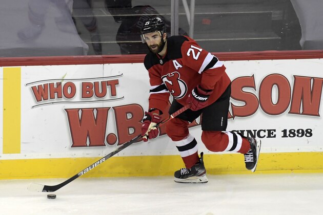 New Jersey Devils right wing Kyle Palmieri (21) skates with the puck during the first period of an NHL hockey game against the New York Islanders Saturday, March 13, 2021, in Newark, N.J. (AP Photo/Bill Kostroun)