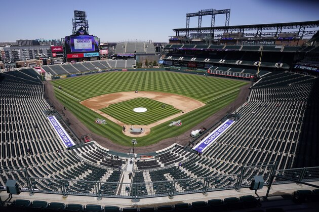 Workers prepare Coors Field on Wednesday, March 31, 2021, in Denver, the day before the Colorado Rockies' season-opener against the Los Angeles Dodgers. (AP Photo/David Zalubowski)