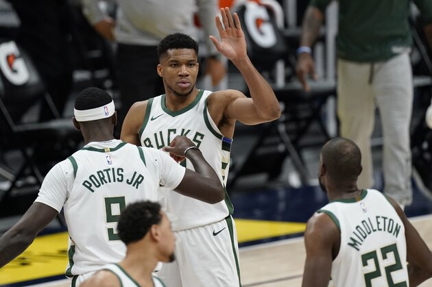 Milwaukee Bucks forward Giannis Antetokounmpo (34) is congratulated after dunking the ball for a basket by Milwaukee Bucks center Bobby Portis (9) and Milwaukee Bucks forward Khris Middleton (22) in the second half of an NBA basketball game Monday, Feb. 8, 2021, in Denver. Milwaukee won 125-112. (AP Photo/David Zalubowski)